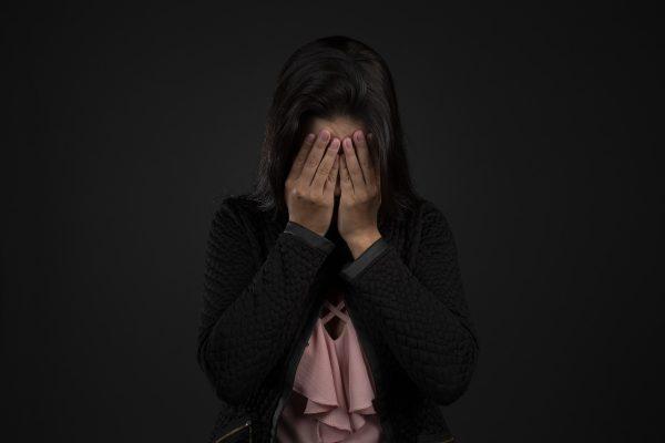 Zaburzenia osobowości w psychologii - kobieta chowa twarz w rękach